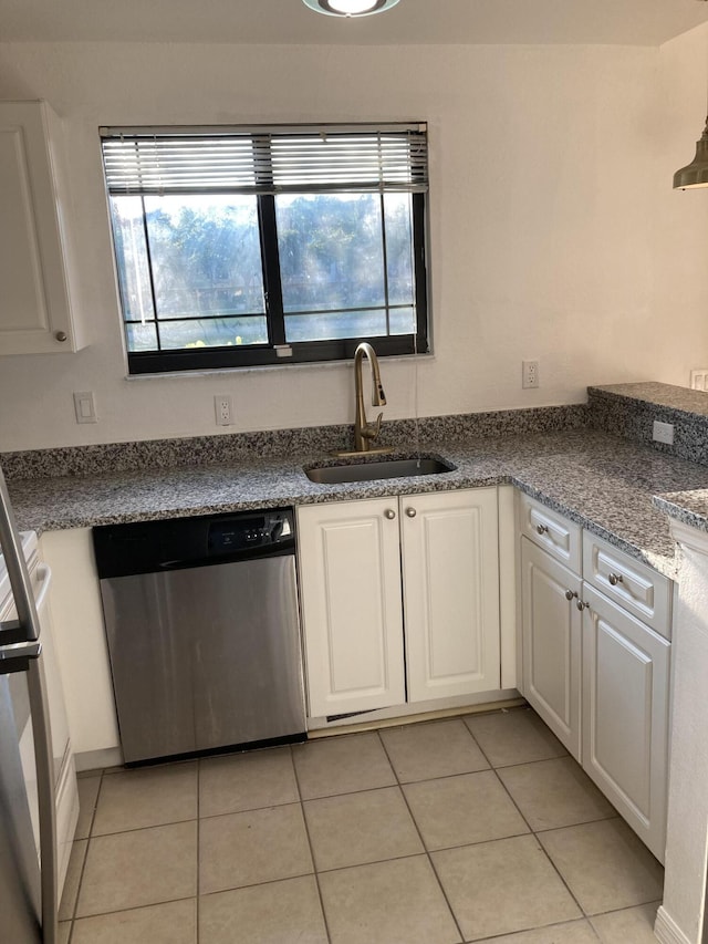 kitchen with sink, white cabinetry, light tile patterned floors, stove, and stainless steel dishwasher