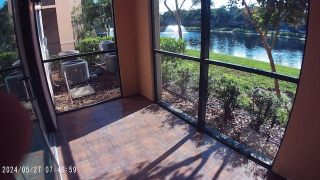 sunroom / solarium featuring a water view