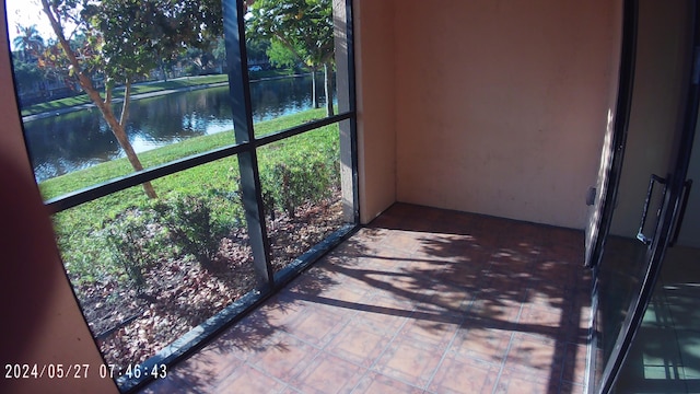 unfurnished sunroom featuring a water view