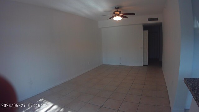 tiled spare room with ceiling fan