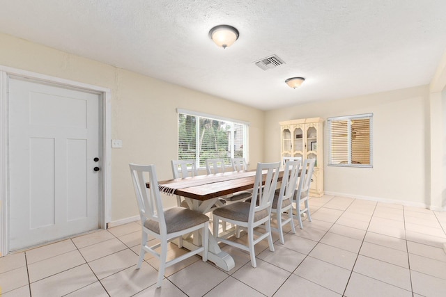 dining room with light tile patterned flooring and a textured ceiling