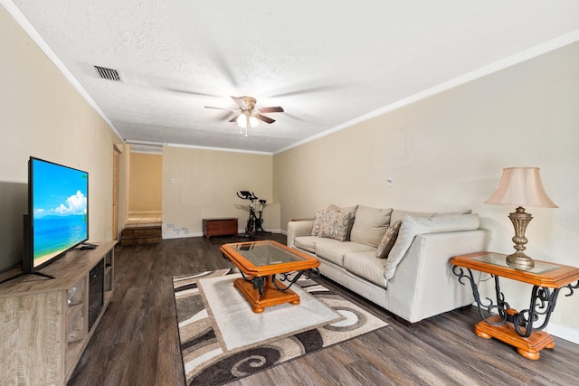 living room featuring dark hardwood / wood-style floors, ceiling fan, ornamental molding, and a textured ceiling