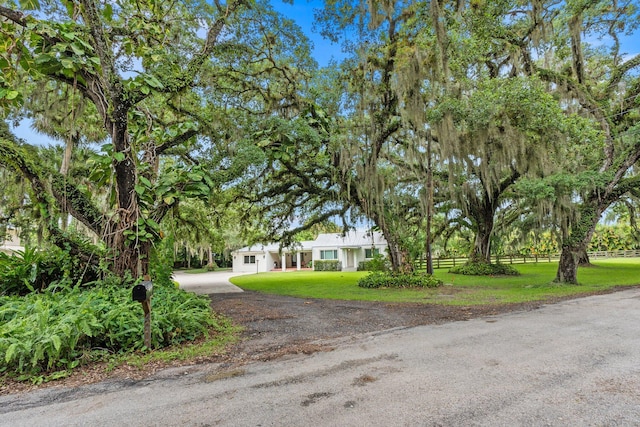 obstructed view of property featuring a front lawn