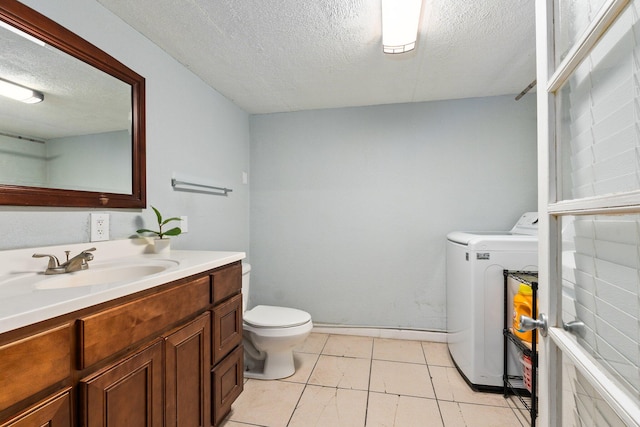 bathroom featuring washer / dryer, tile patterned flooring, a textured ceiling, toilet, and vanity