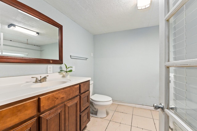 bathroom featuring tile patterned flooring, a textured ceiling, vanity, and toilet