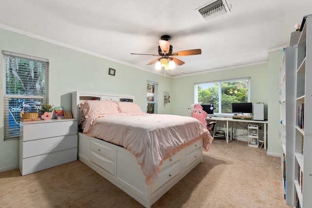 carpeted bedroom with ceiling fan and crown molding