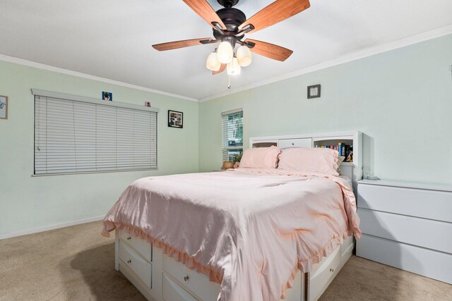 carpeted bedroom with ceiling fan and ornamental molding