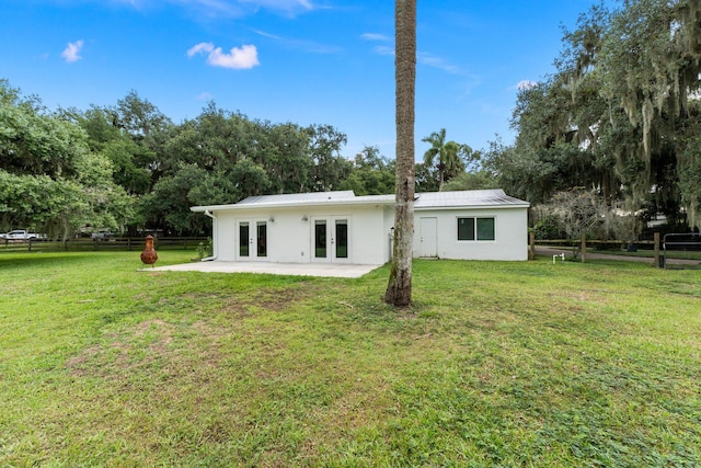 back of property featuring french doors and a yard