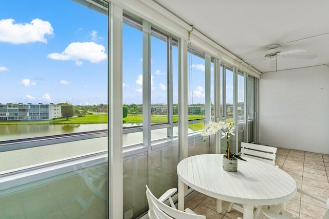 sunroom with a water view and ceiling fan