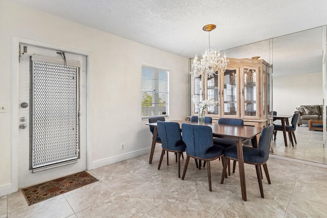 dining space featuring a textured ceiling and a notable chandelier