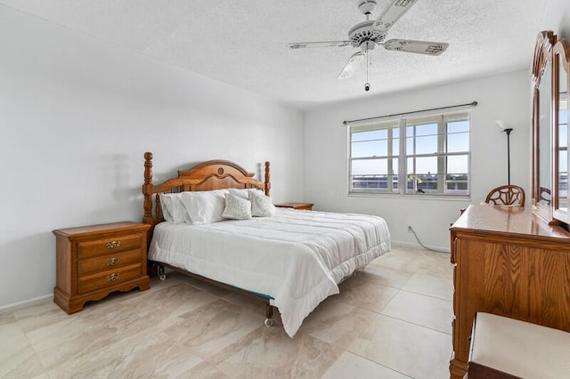 bedroom with ceiling fan and a textured ceiling