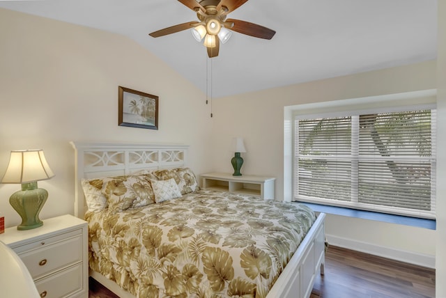 bedroom featuring dark hardwood / wood-style flooring, vaulted ceiling, and ceiling fan