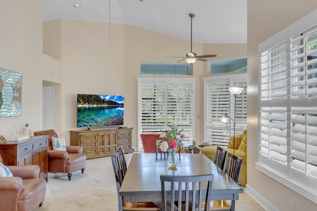 dining room featuring light tile patterned floors, high vaulted ceiling, and ceiling fan