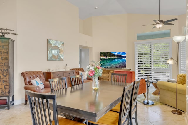 tiled dining area with ceiling fan and high vaulted ceiling