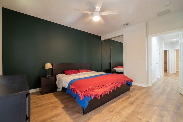 bedroom with light hardwood / wood-style floors, a closet, and ceiling fan