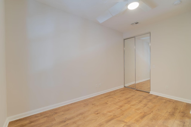 unfurnished bedroom with a closet, light wood-type flooring, and ceiling fan