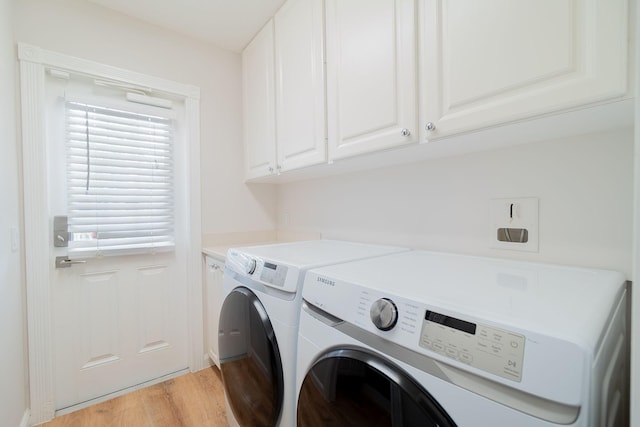 laundry area with light hardwood / wood-style floors, cabinets, and washer and clothes dryer