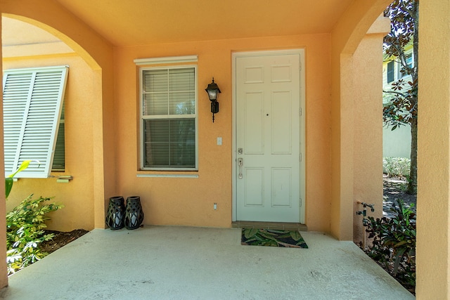 view of exterior entry with a patio