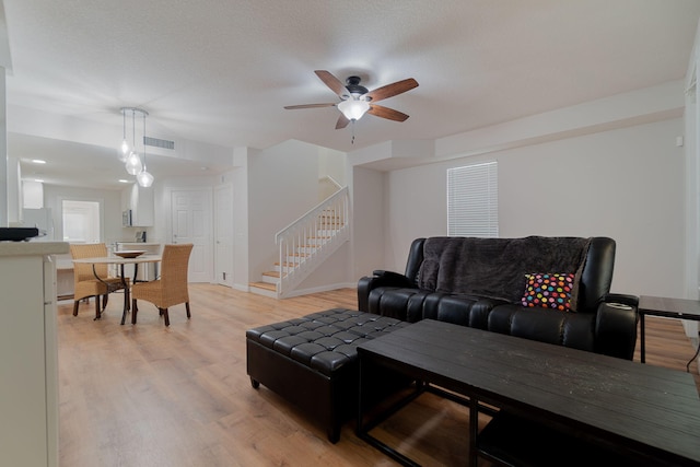 living room featuring light hardwood / wood-style floors and ceiling fan