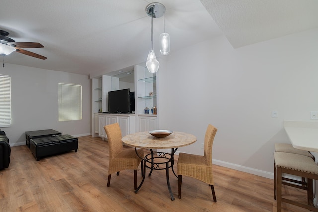 dining space with light wood-type flooring and ceiling fan