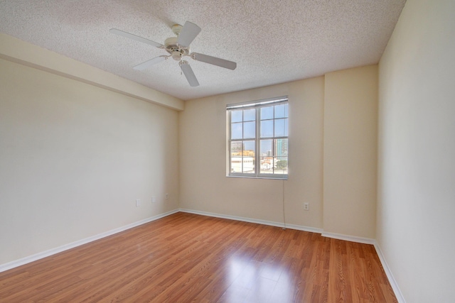 spare room featuring ceiling fan, a textured ceiling, and light wood-type flooring