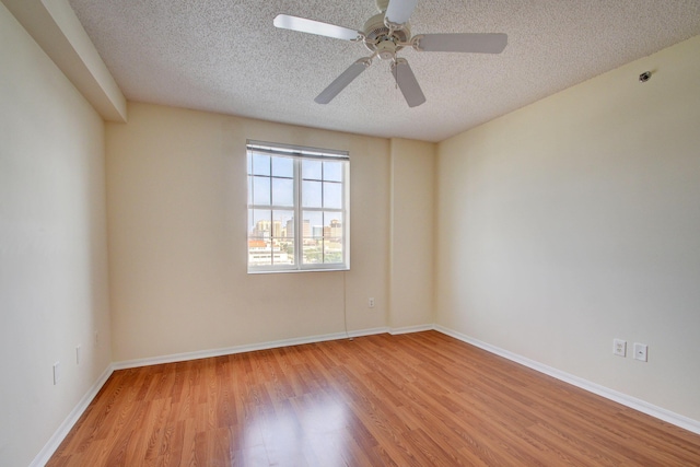 empty room featuring ceiling fan, a textured ceiling, and light hardwood / wood-style flooring