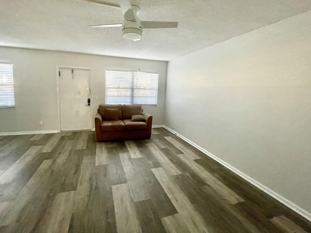 sitting room featuring ceiling fan, dark wood-type flooring, and a textured ceiling