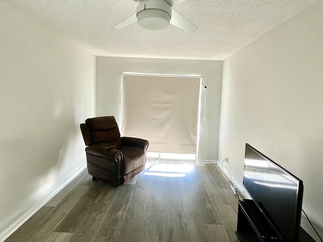 living area featuring ceiling fan, a textured ceiling, and hardwood / wood-style flooring