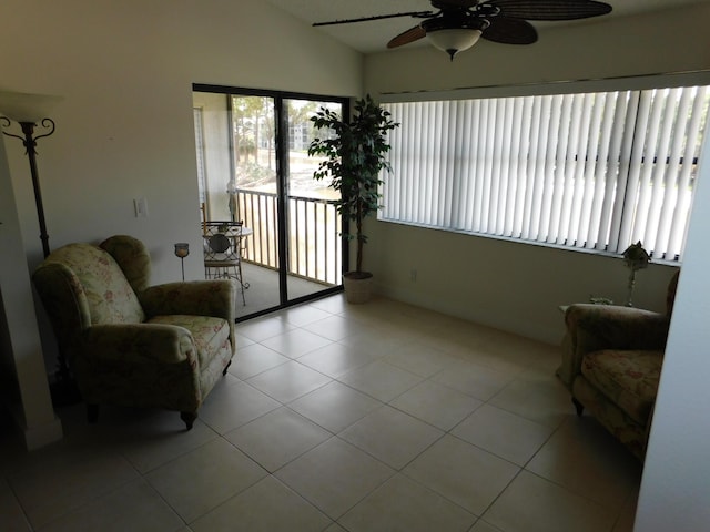 living area with ceiling fan, light tile patterned floors, and lofted ceiling