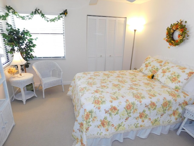 carpeted bedroom with ceiling fan and a closet