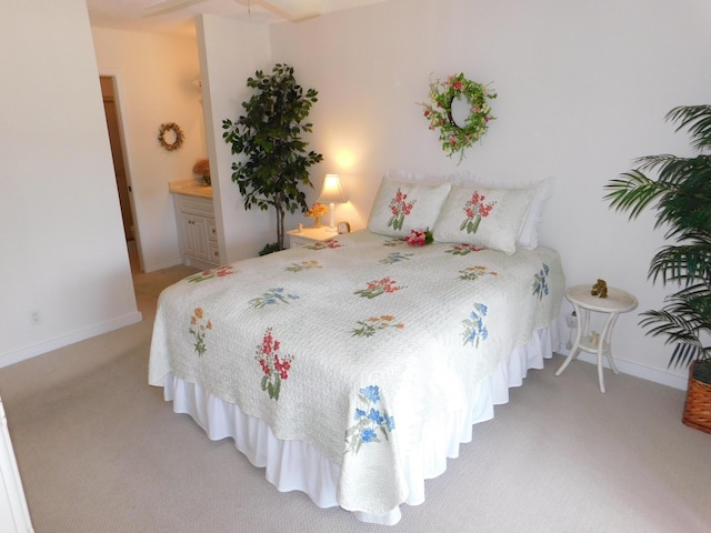 bedroom featuring light colored carpet and ensuite bath