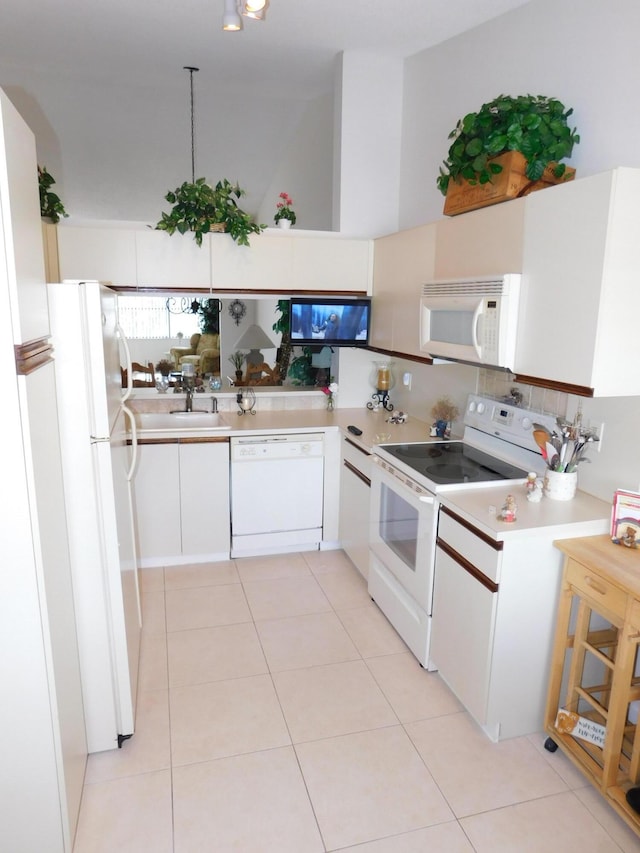 kitchen featuring light tile patterned floors, sink, white appliances, and white cabinetry