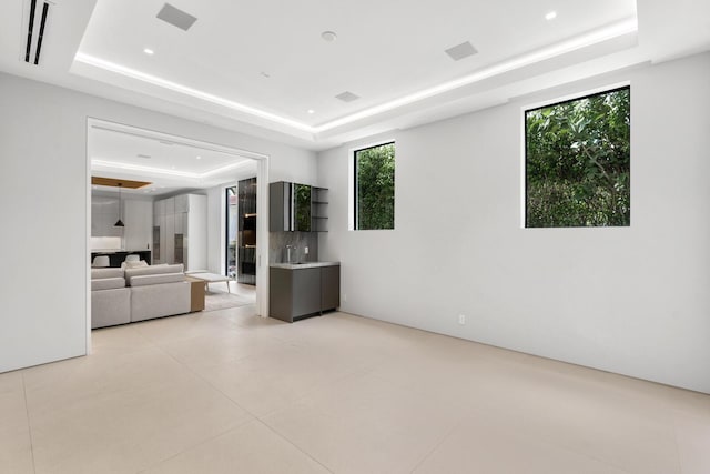 unfurnished living room with a tray ceiling