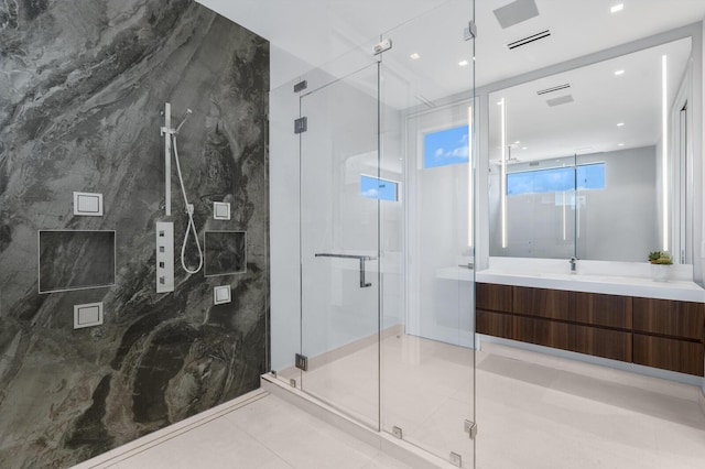 bathroom with tile patterned flooring, vanity, an enclosed shower, and tile walls