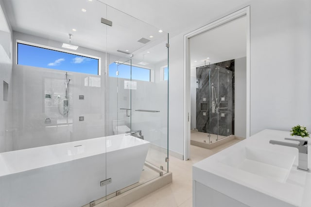 bathroom featuring tile patterned flooring, shower with separate bathtub, and vanity