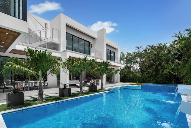 view of swimming pool featuring pool water feature and a patio