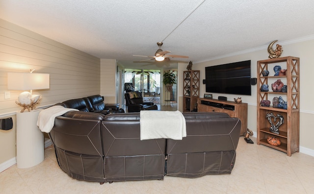 tiled living room featuring ceiling fan, crown molding, wood walls, and a textured ceiling