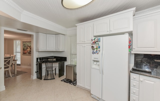 kitchen featuring light tile patterned floors, decorative backsplash, white fridge with ice dispenser, ornamental molding, and white cabinets