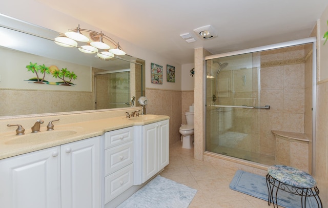 bathroom featuring toilet, vanity, tile walls, tile patterned floors, and an enclosed shower