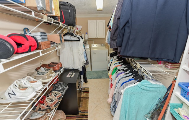 spacious closet featuring light tile patterned flooring and washing machine and clothes dryer