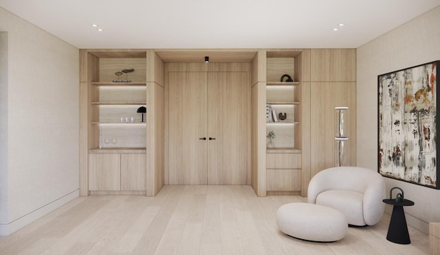 living area featuring hardwood / wood-style floors, built in features, and wood walls