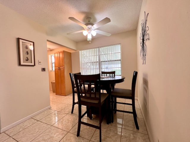 tiled dining area featuring ceiling fan and a textured ceiling