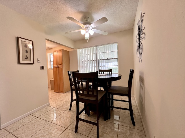 dining area with baseboards, a ceiling fan, and a textured ceiling