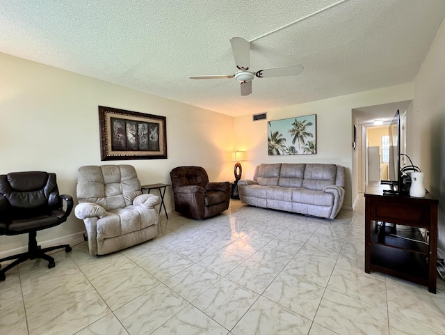 living area with visible vents, a ceiling fan, a textured ceiling, and marble finish floor