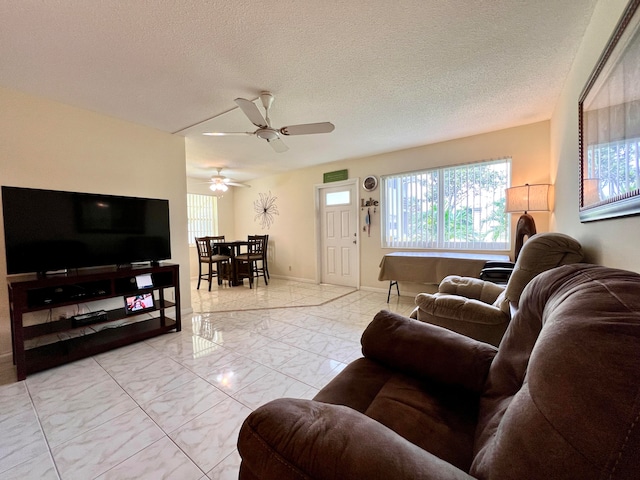 tiled living room featuring ceiling fan and a textured ceiling