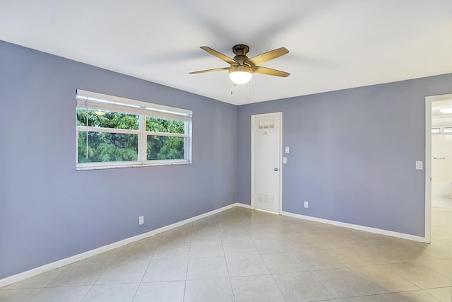 spare room with ceiling fan and light tile patterned floors