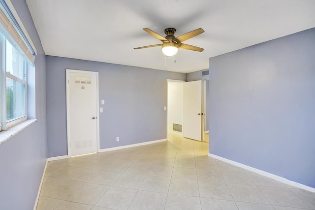 tiled spare room with ceiling fan