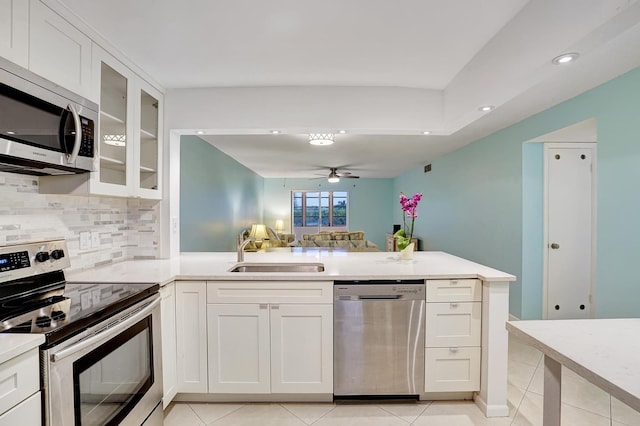 kitchen featuring sink, ceiling fan, light tile patterned flooring, white cabinetry, and stainless steel appliances