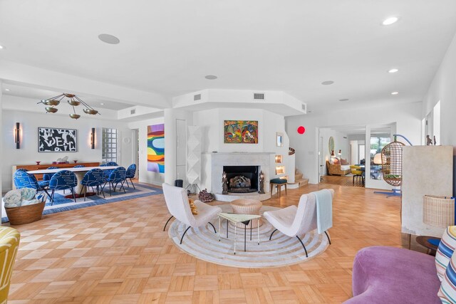 living room featuring light parquet floors and a fireplace