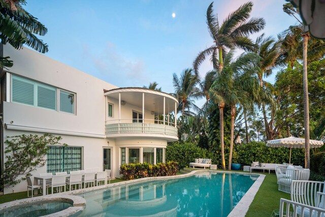 view of pool featuring a lawn, an in ground hot tub, and a patio